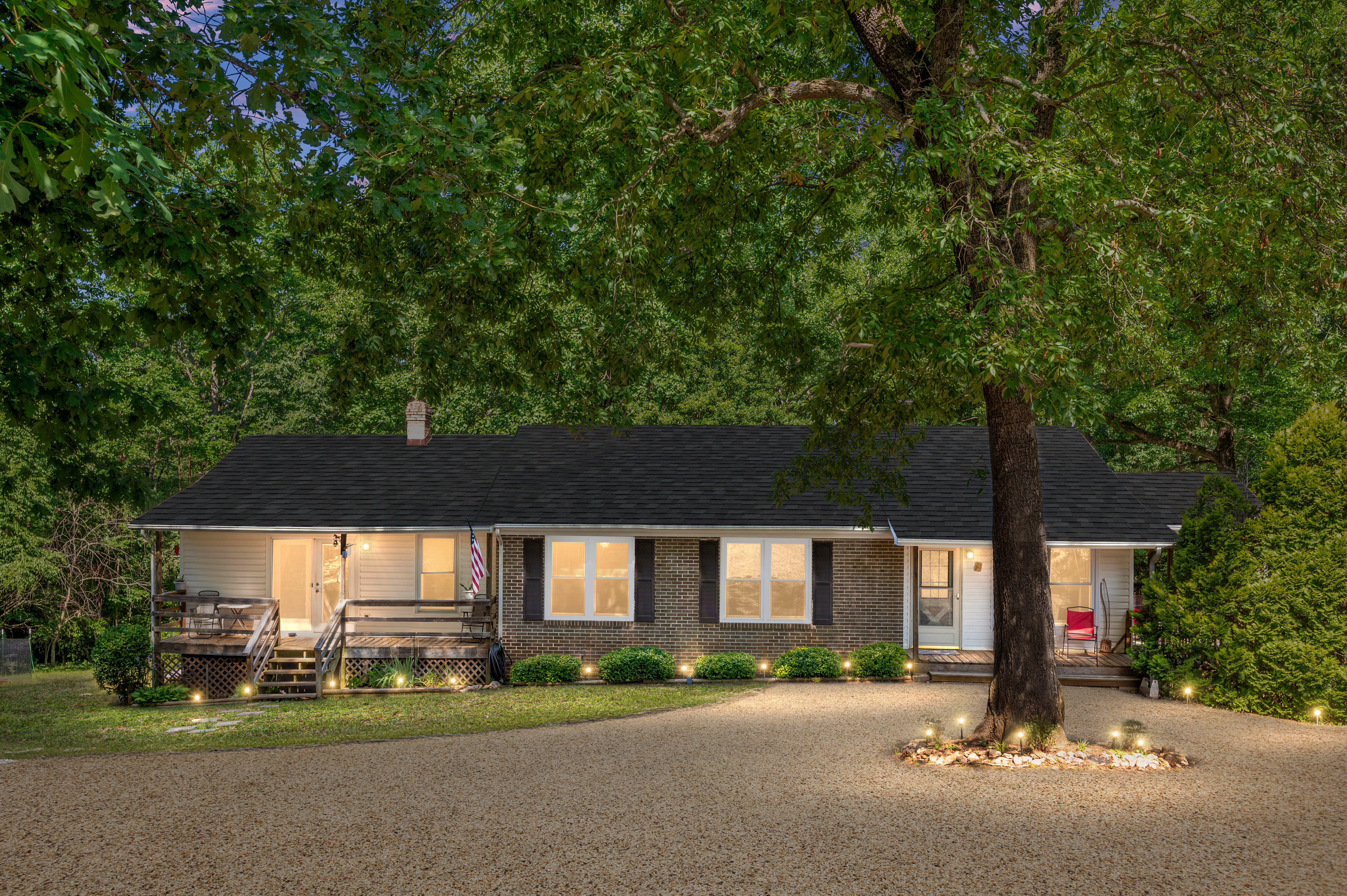 A ranch-style home with black shutters and an attached apartment