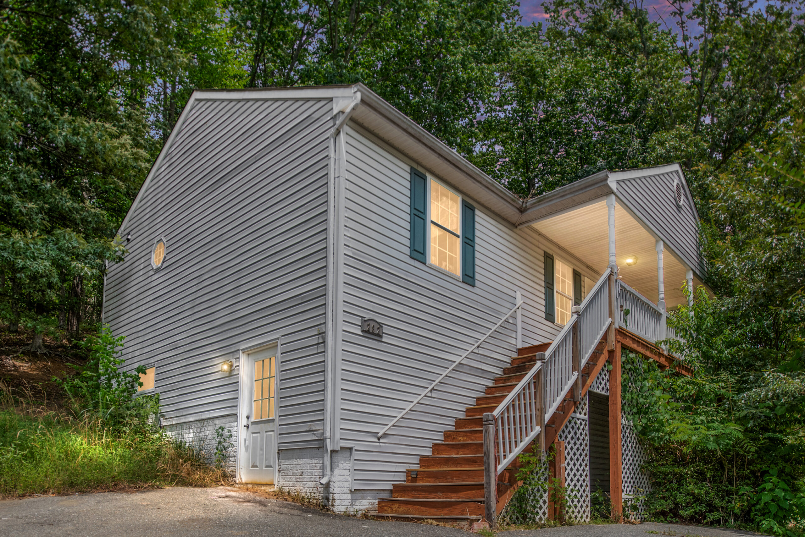 A home with blue shutters and stairs leading up a front porch