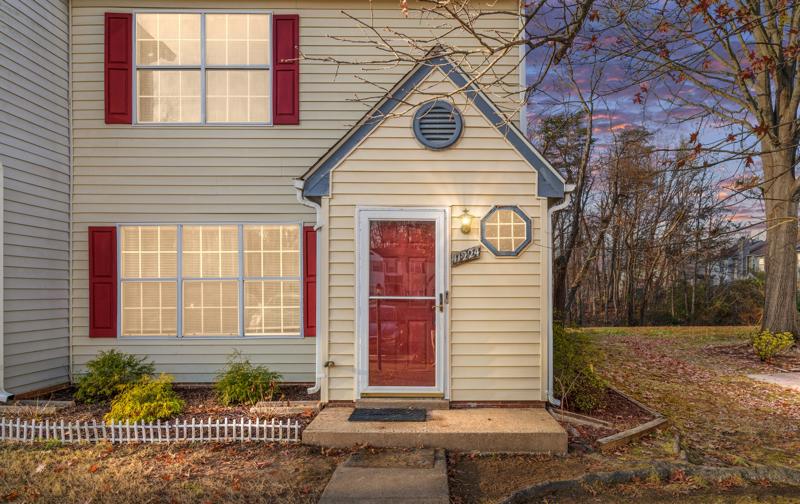 Townhome for sale in Fredericksburg VA with yellow siding, red shutters, and a red front door