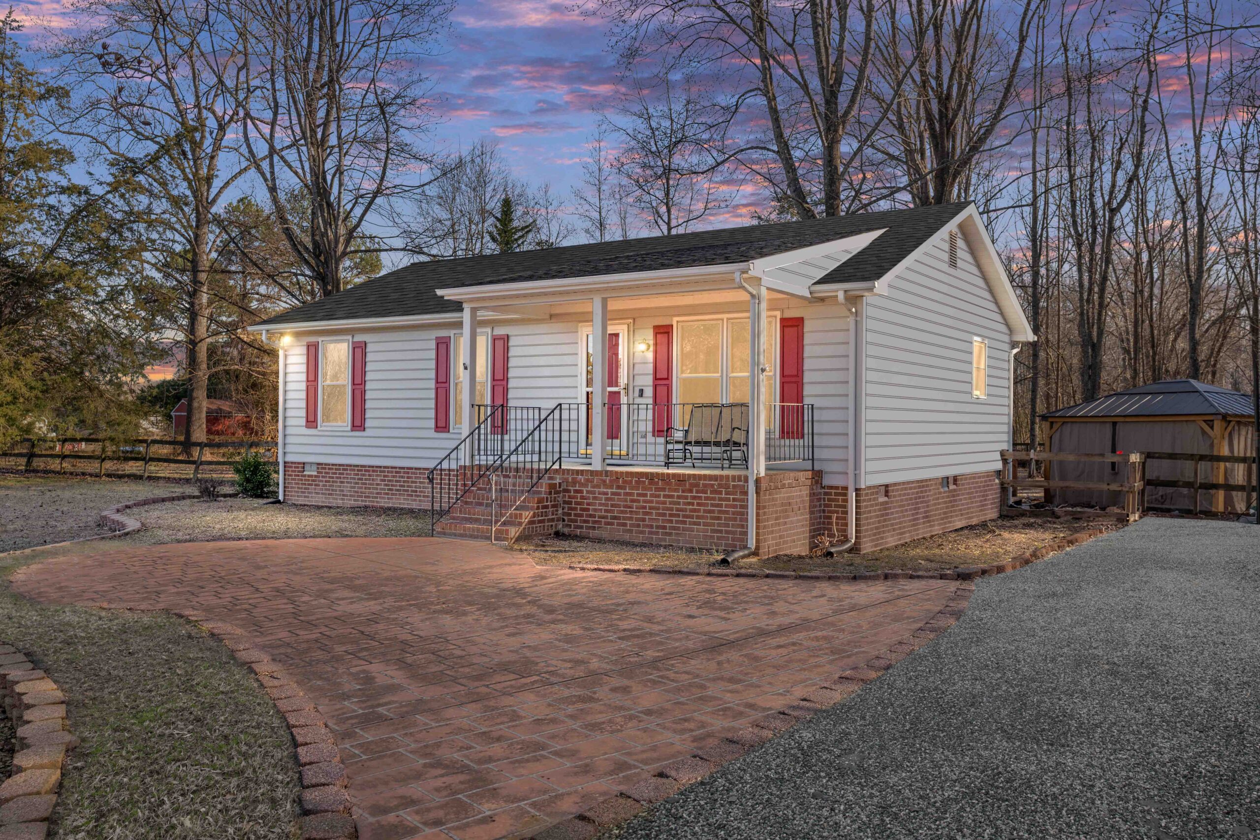 A charming rambler with light gray siding and red shutters and door for sale in Caroline County VA